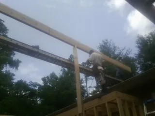 Carpenter setting a ridge beam over a new addition frame — Ice Dam Removal by Roofing Brothers in Myrtle Beach