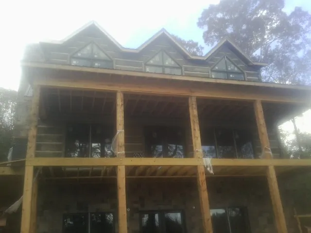 Dormers and porch framing on a large log home under construction — Roof Coating work by our crew in Myrtle Beach